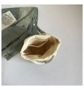 Interior view of quilted tote bag showing a zipper pocket and open slot for organization