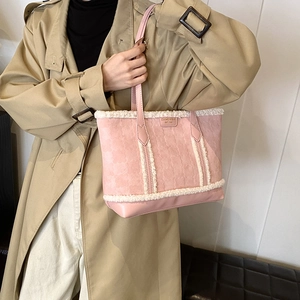Pink embossed tote bag with white plush trim shown as a stylish winter shoulder bag