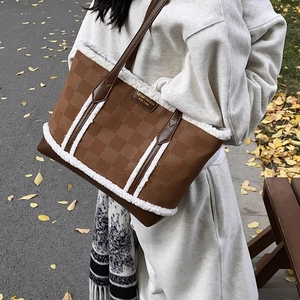 Brown leather tote bag with white plush trim and embossed clover patterns for autumn