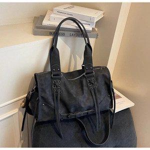 Détail du sac cabas en simili cuir noir avec rivets punk, franges et lanières à œillets