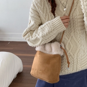 Dettaglio del secchiello in peluche beige e pelle scamosciata marrone con lacci
