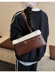 Close-up of brown PU leather bag with white plush trim and metal buckle detail