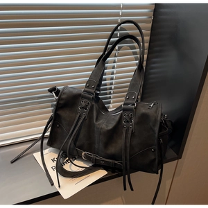 Détails du sac vintage noir avec pampilles à lanières et boucles métalliques
