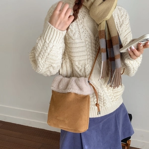 Dettaglio di una borsa a secchiello in peluche con texture scamosciata e coulisse