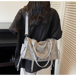 Detail of light grey retro pillow bag showing matte leather texture and shoulder strap