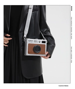 Detail of creative vintage camera crossbody bag with silver and brown faux leather finish