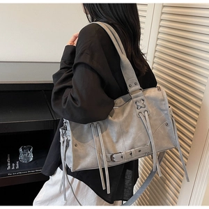 Detail of grey vintage motorcycle tote bag featuring tassel accents and a wide strap