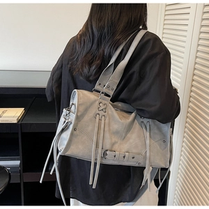 Sac fourre-tout vintage gris avec franges et boucles porté par un mannequin de dos
