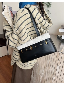 Detail showing plush faux shearling trim and gold buckle on a black leather shoulder bag