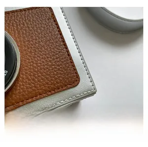Macro shot of silver textured fabric and brown pebble leather stitching on camera bag