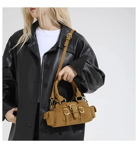 Detail of vintage brown suede crossbody bag with multiple cargo pockets and metal buckles