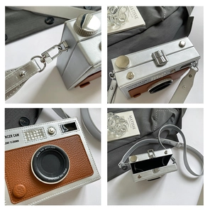 Detail view of silver hard shell camera-shaped bag with brown leather and chain strap