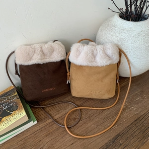 Dettaglio delle borse a secchiello in peluche marrone scuro e beige in finta pelle