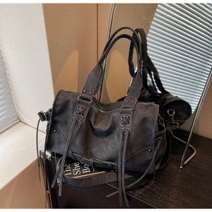 Détail du sac Boston vintage gris avec œillets métalliques et lanières croisées