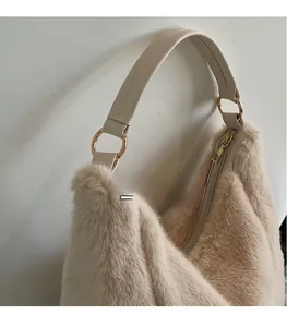 Close-up of beige faux fur tote bag with wide leather handle and gold metal rings