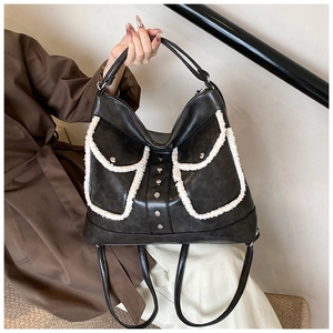 Detail of black faux leather backpack with white shearling trim pockets and silver studs