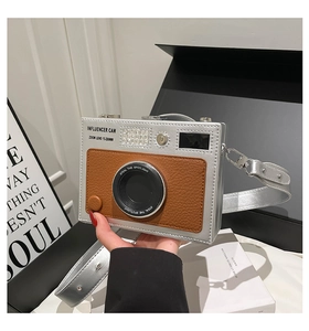 Detail of creative camera-shaped crossbody bag with silver leather and zoom lens design