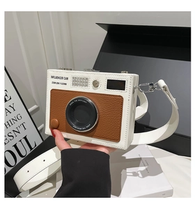 Close-up of vintage camera shaped crossbody bag featuring white and brown leather texture