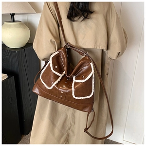 Detail of vintage brown PU leather shoulder bag with white faux fur trim and metal rivets