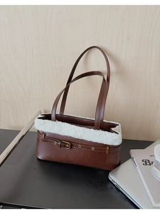 Detail of brown PU leather shoulder bag with white faux shearling trim and metal buckle