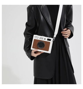 Detail of creative camera-shaped crossbody box bag with vintage brown leather accents