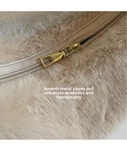 Detail of a smooth golden metal zipper on a soft fluffy plush underarm shoulder bag