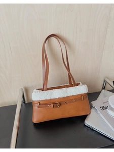 Detail of caramel PU leather shoulder bag with plush shearling trim and gold buckle accent