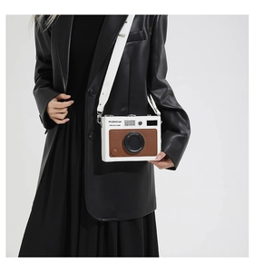Detailed close-up of a retro camera-shaped crossbody bag with textured leather panel