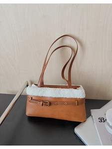 Close-up of caramel PU leather bag with white plush trim and silver metallic buckle detail
