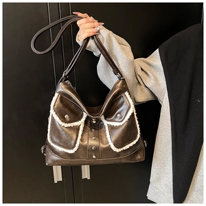 Detail of vintage brown leather tote bag with white plush trim and silver buckles
