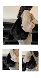 Detail view of black faux fur hobo bag with leather strap and golden metal buckle