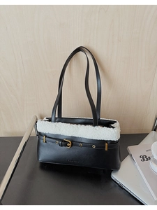 Detail of black leather bucket bag with white faux fur trim and gold buckle accent
