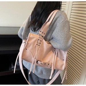 Détail du sac à main rose en similicuir avec cordons de serrage et bandoulière amovible