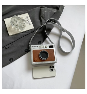 Detail of creative vintage camera crossbody bag with silver PU and brown leather finish