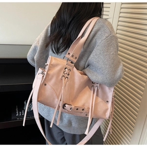 Détail du sac cabas rose clair en similicuir avec laçage croisé et longues franges déco