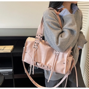Pink moto tote bag with grommets and lacing detail shown on a model for scale