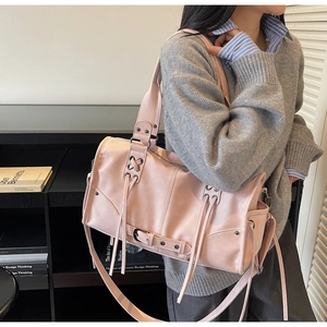 Vue latérale d'un sac cabas vintage rose avec lacets et poche latérale porté par un mannequin