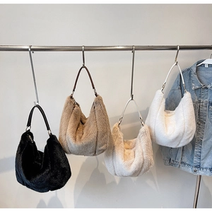Detailed view of four assorted plush faux fur hobo bags hanging on a display rack