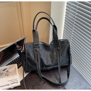 Gros plan d'un sac Boston en cuir PU gris foncé avec laçage croisé et longues franges