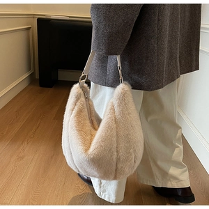 Detail of plush beige faux fur hobo bag with leather strap and metal hardware detail