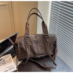 Détail du sac fourre-tout en cuir vintage marron foncé avec lacets croisés et rivets décoratifs