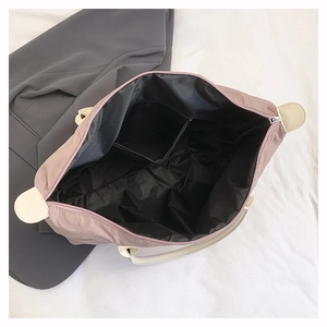 Detailed interior view of a purple tote bag showing black nylon lining and small pocket