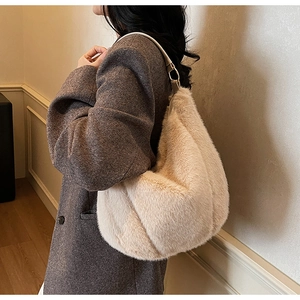 Detail of soft beige plush tote bag with minimalist leather strap and metal ring