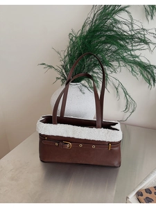 Detail of brown PU shoulder bag featuring white faux fur trim and gold buckle accent