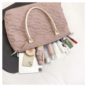Detail view of pink quilted tote bag showing large capacity for laptop and daily items