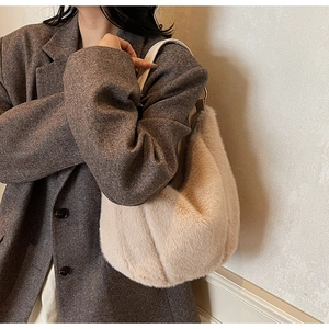 Detailed texture of fluffy plush tote bag with white leather strap on a model shoulder
