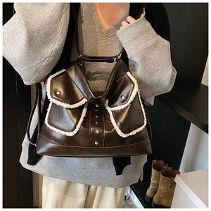 Detail showing deep brown PU leather with plush fleece trim and silver buckles on a shoulder bag