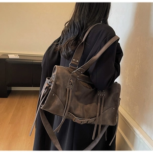 Détail du sac cabas vintage marron foncé avec longues franges et boucles métalliques