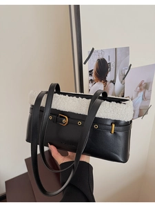 Detail of black leather shoulder bag featuring white plush faux fur trim and gold buckle