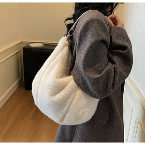 Model wearing a fluffy off-white faux fur tote bag with leather shoulder straps